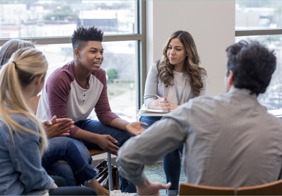 How long therapy takes to work depends on a child's diagnosis and the intensity of treatment. In this image four teens sit in a circle while a therapist moderates.