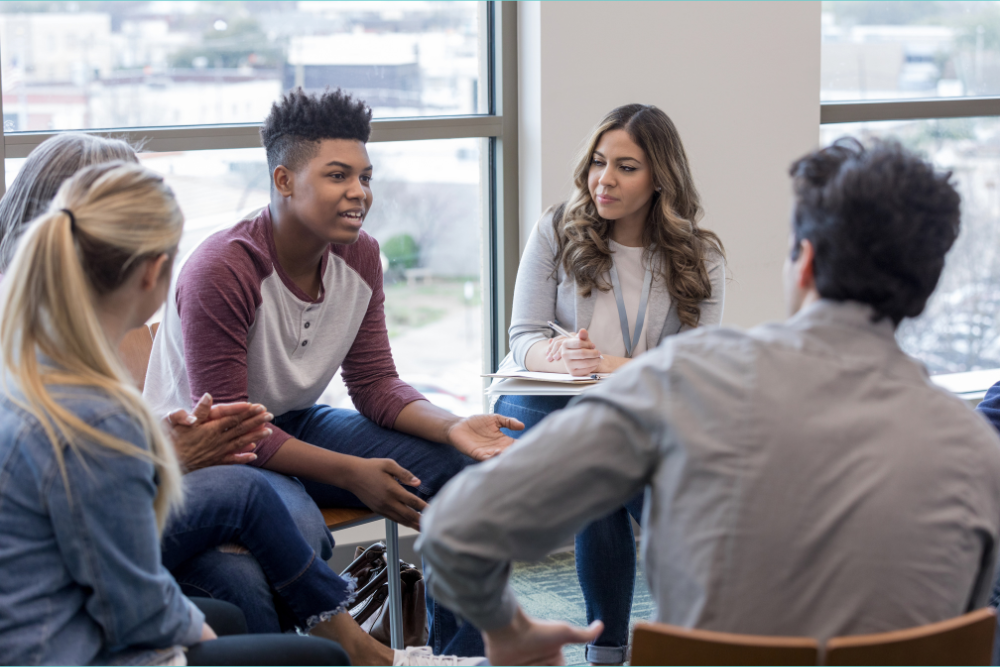 How long therapy takes to work depends on a child's diagnosis and the intensity of treatment. In this image four teens sit in a circle while a therapist moderates.
