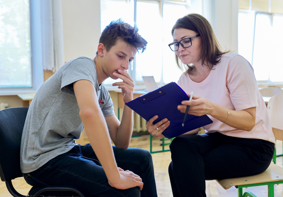 A teenage boy and female therapist discuss therapy goals.
