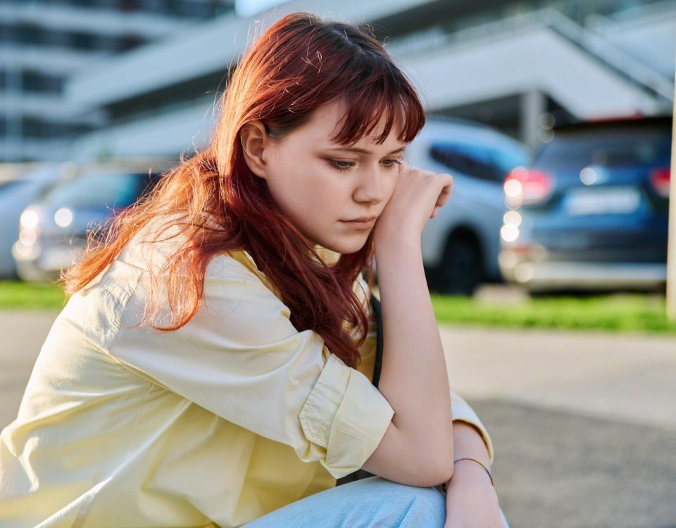 Upset sad unhappy young female sitting outdoor on steps