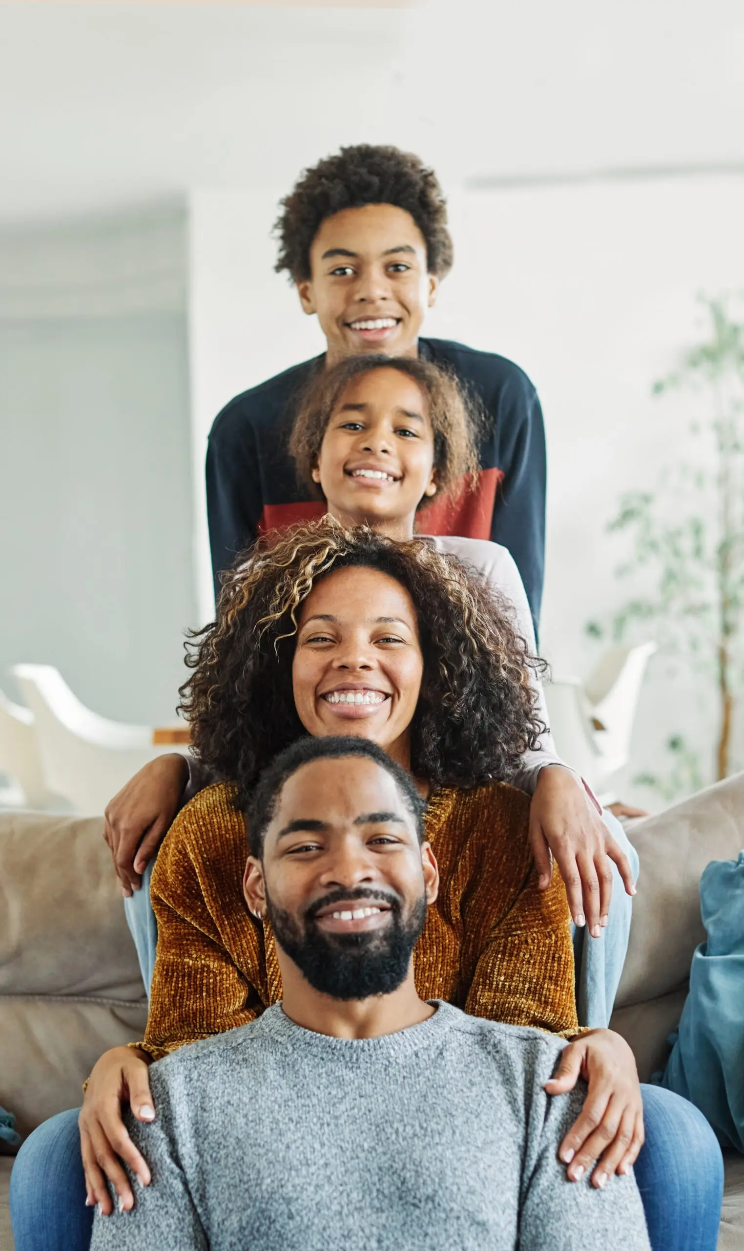 Family of four posing in a fun "stack" while smiling.