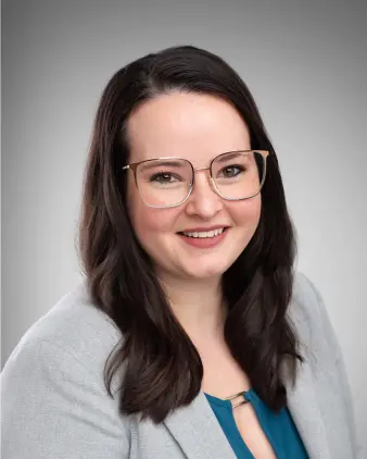 Woman in light clothes, smiling with dark hair.