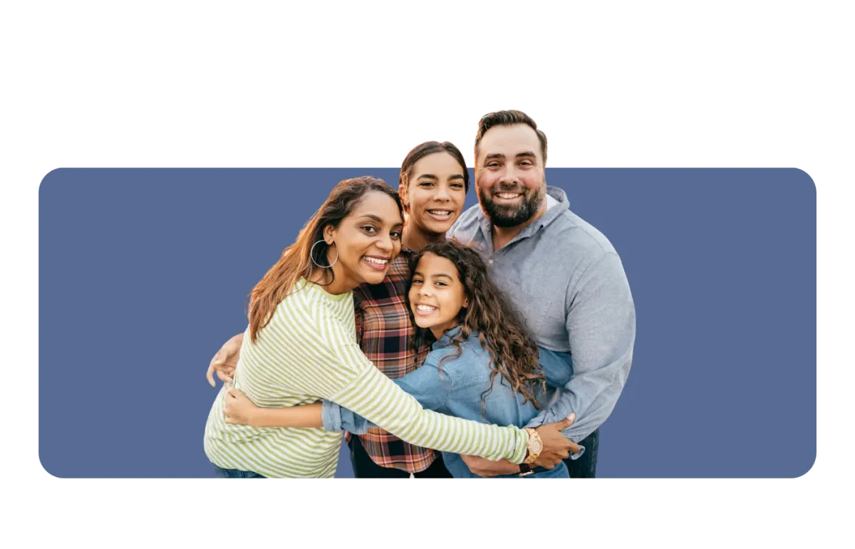 Family of four embracing and smiling.