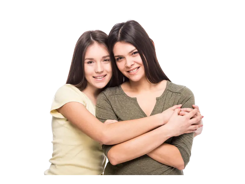 Two young women smiling and embracing.