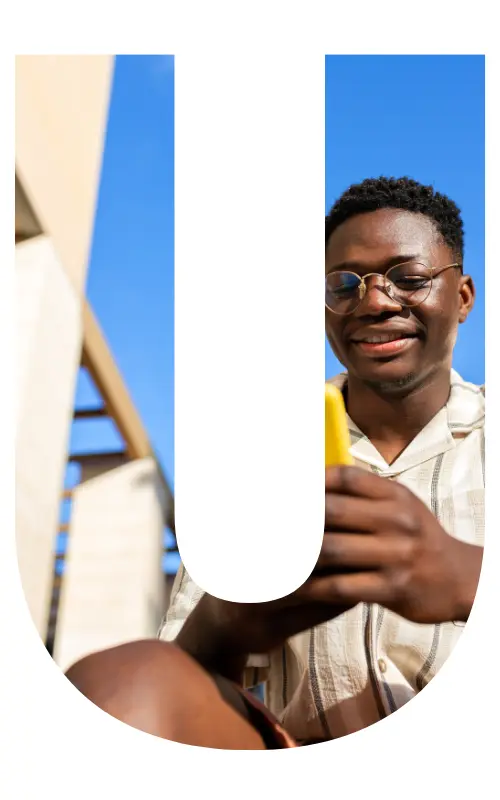 Image is in the shape of the letter "u" and displaying a young man smiling at his phone.