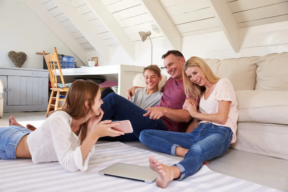 A small, happy family sitting together in a modern home.